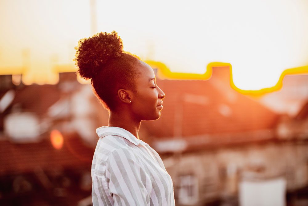 woman relaxing on the rooftop in the summer - summer mental health