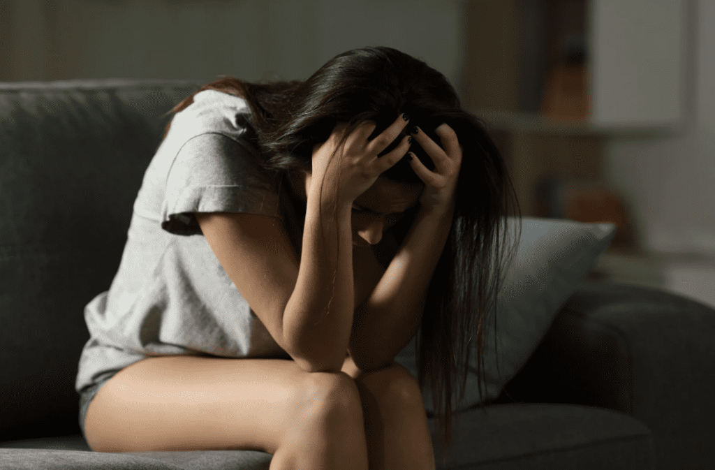 A woman sitting with her head in her heads.