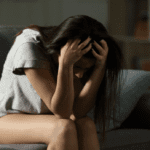 A woman sitting with her head in her heads.