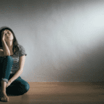 A woman sitting in an empty room.