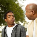 father talking with his teenage son outside