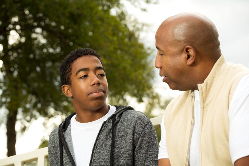 father talking with his teenage son outside