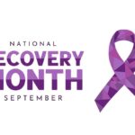 Purple geometric ribbon symbol with the words “National Recovery Month September,” representing awareness for recovery and mental health.