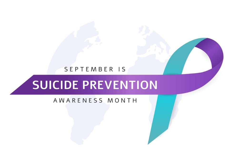 Purple and teal ribbon with text reading ‘September is Suicide Prevention Awareness Month.'